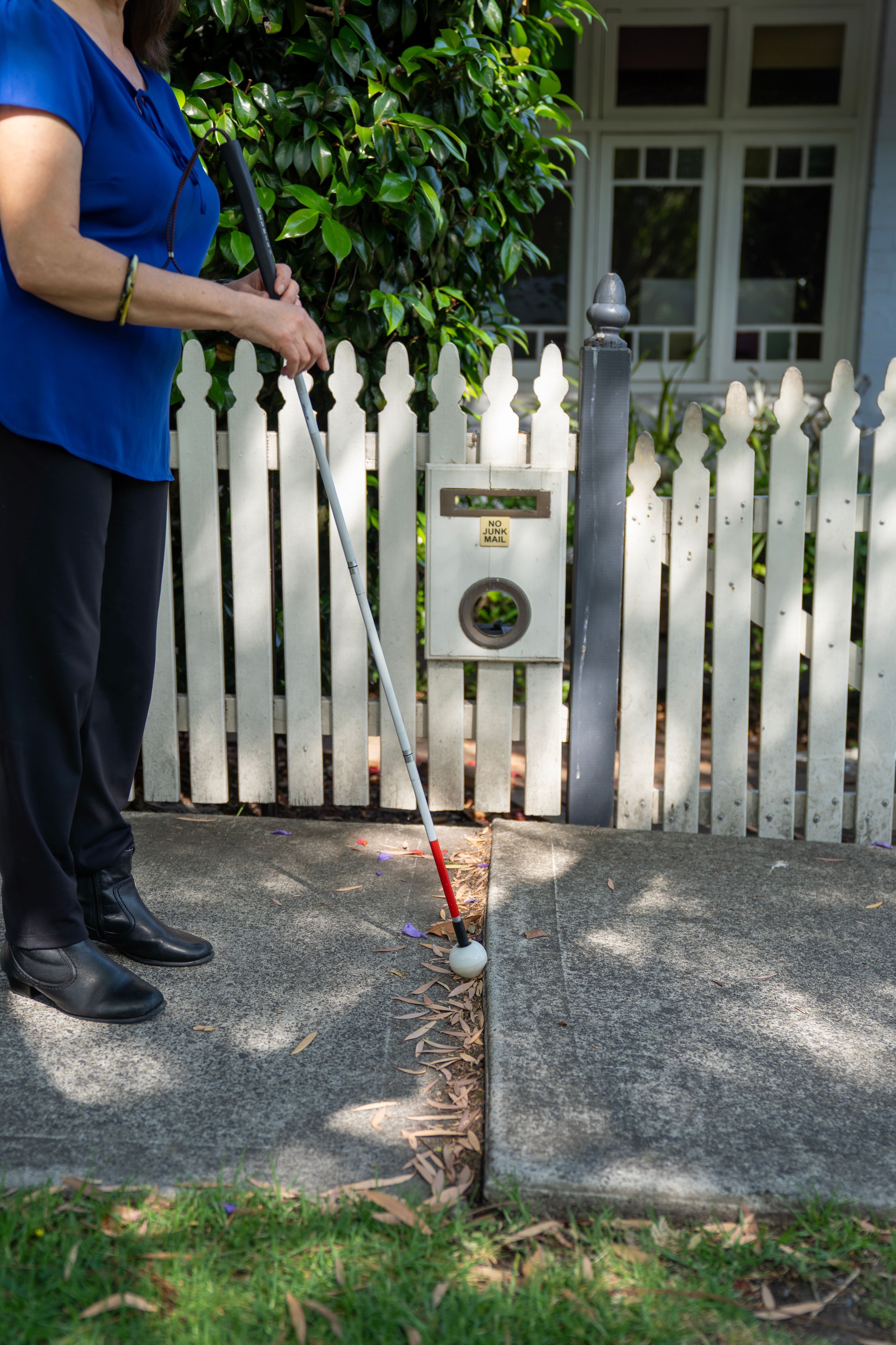 A close up of a cane on the footpath.