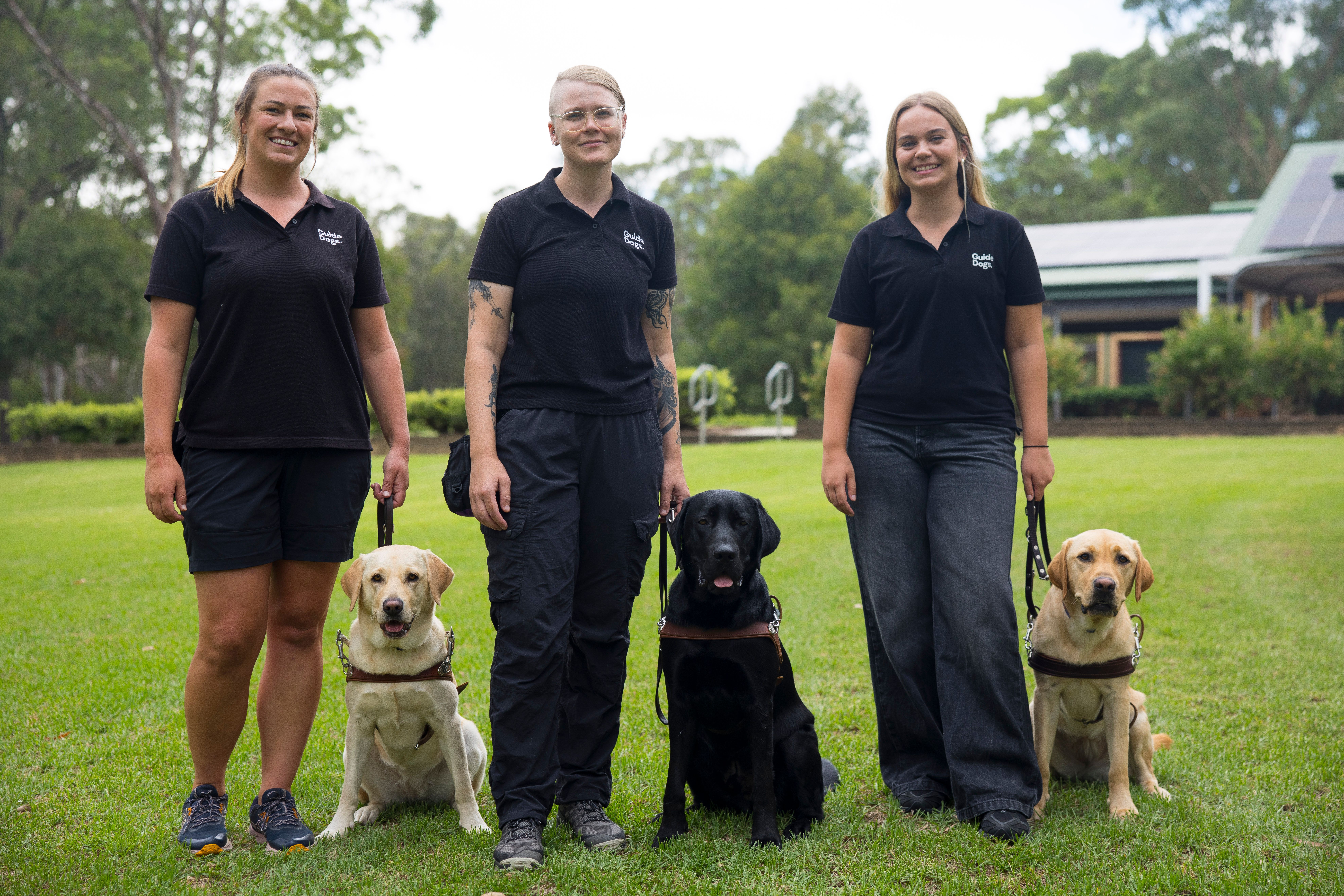 Three Guide Dog Trainers with Labradors.