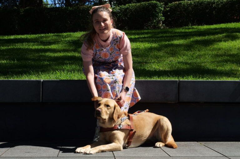 Charlotte sitting with her Guide Dog Bronte.