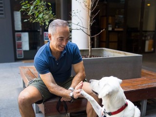 A Puppy Raiser showing shake with a puppy.