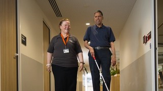 A Client using their cane with an O and M.