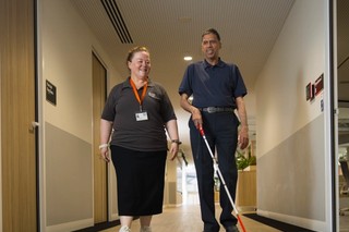 A Client using their cane with an O and M.