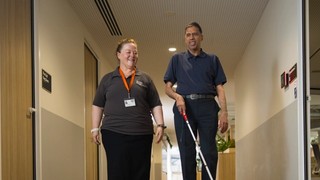A Staff member and a Client walking together.