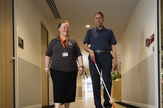 A Staff member and a Client walking together.
