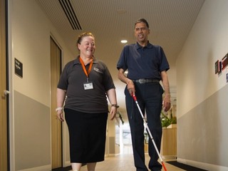 A Staff member and a Client walking together.