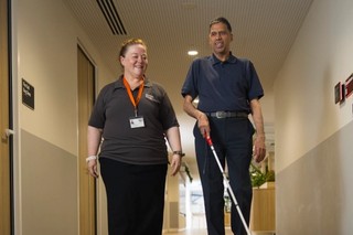 A staff member walking with a Client.