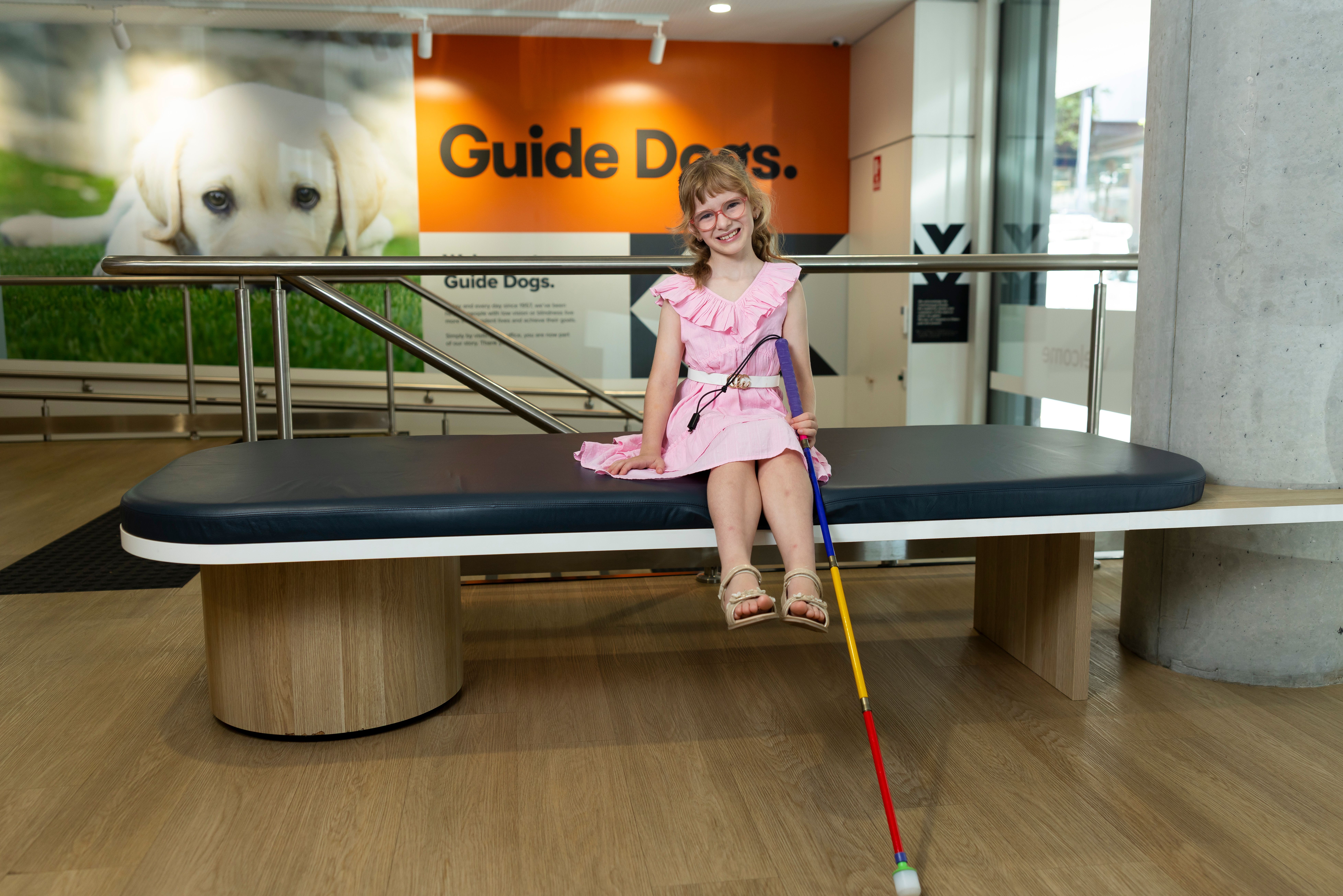 Ivy sitting with her cane smiling. 