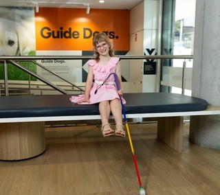 Ivy sitting with her cane smiling.