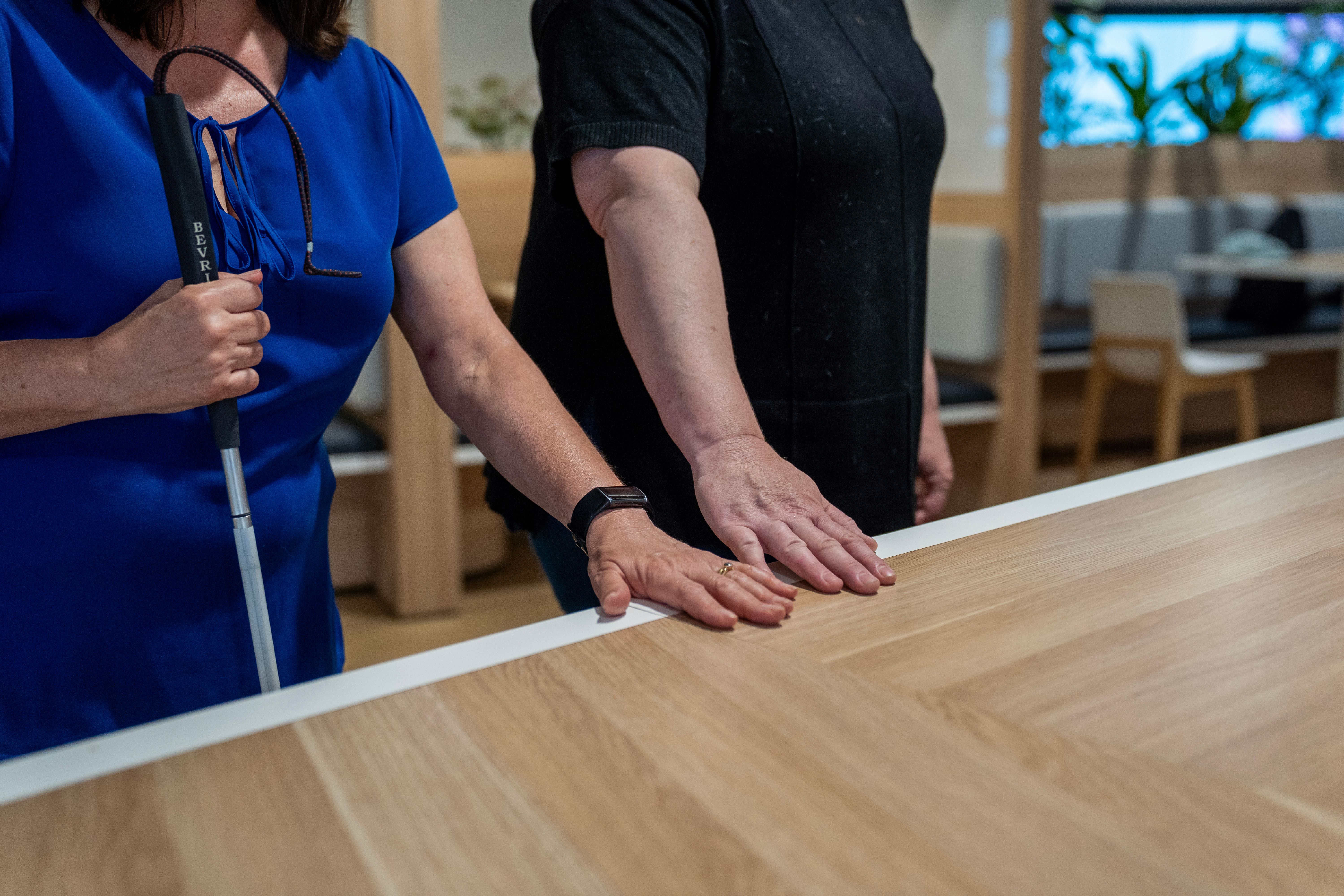 A person guiding another to a table.