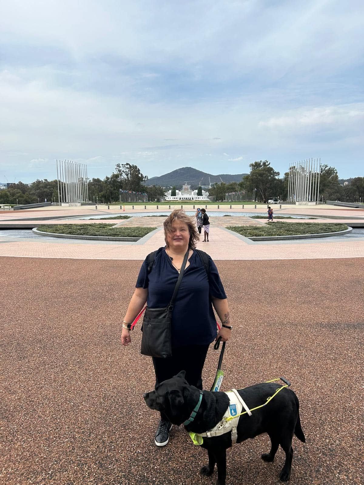 Lee standing with Guide Dog Frankie outside.