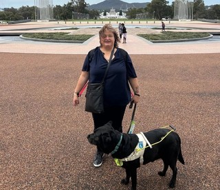 Lee standing with her Guide Dog Frankie.