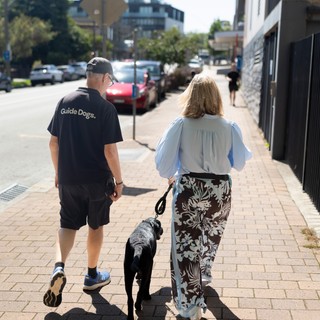 A Puppy Raiser walking with staff.