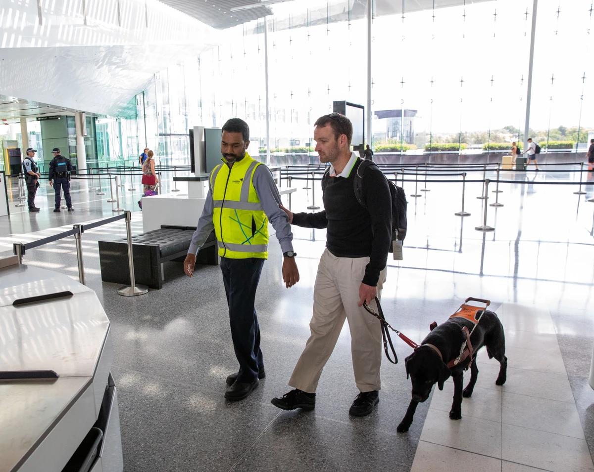 Dan being guided through an airport with his Guide Dog. 