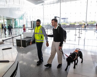 Dan being guided through an airport with his Guide Dog.