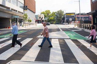 Clients walking across a pedestrian crossing with their canes.