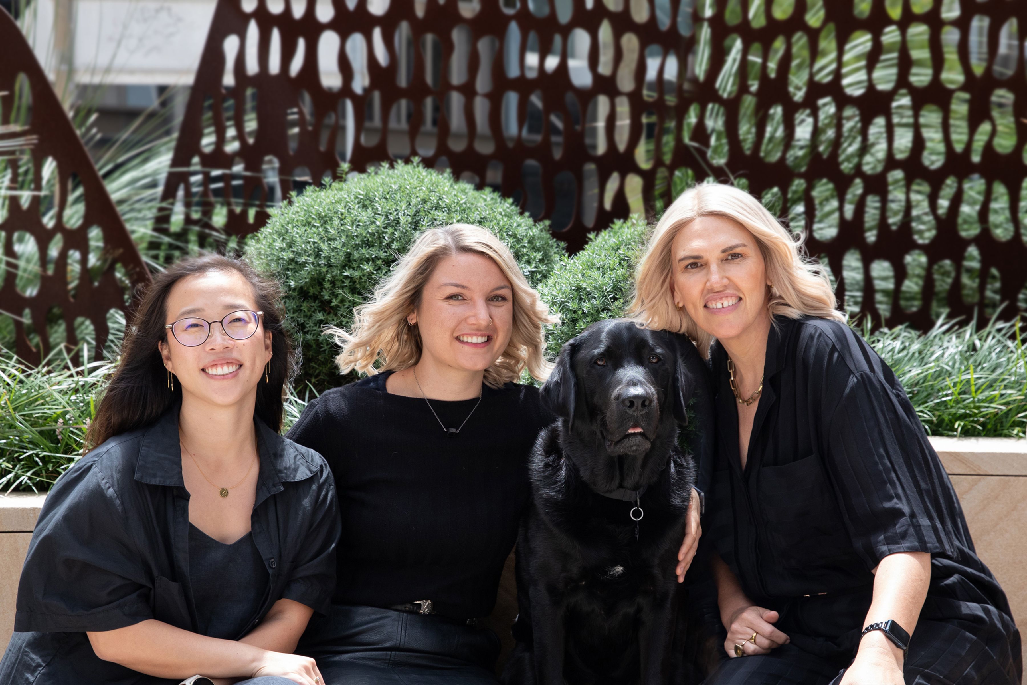 Philanthropy team smiling with Ambassador Dog Fella. 
