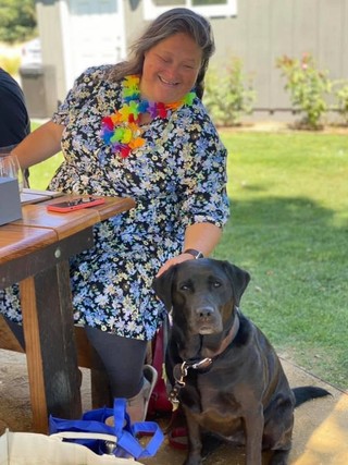 Lee sitting on a chair with Guide Dog Frankie.