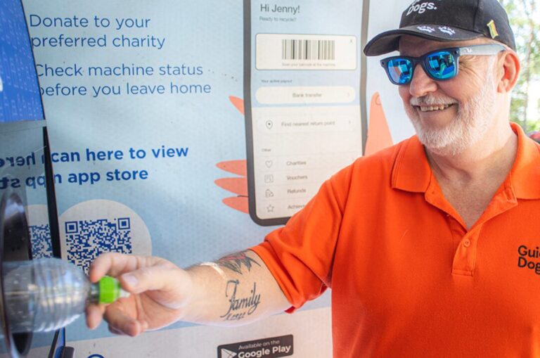 Tony putting a bottle into a kiosk.