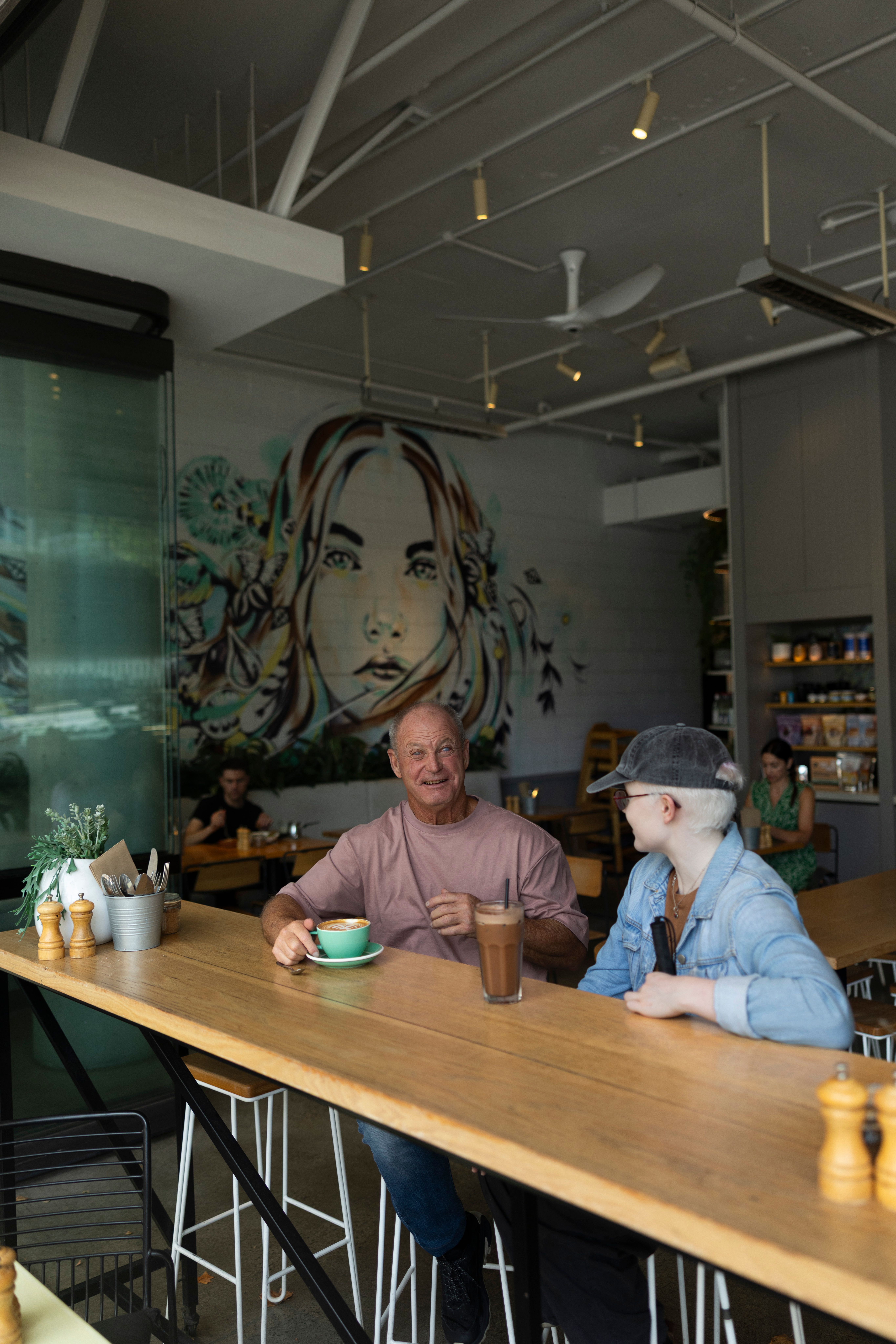 Two people sitting at a cafe. 