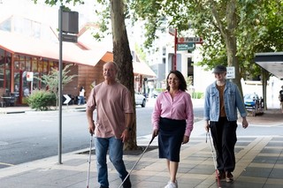 Three Guide Dogs Clients walking together