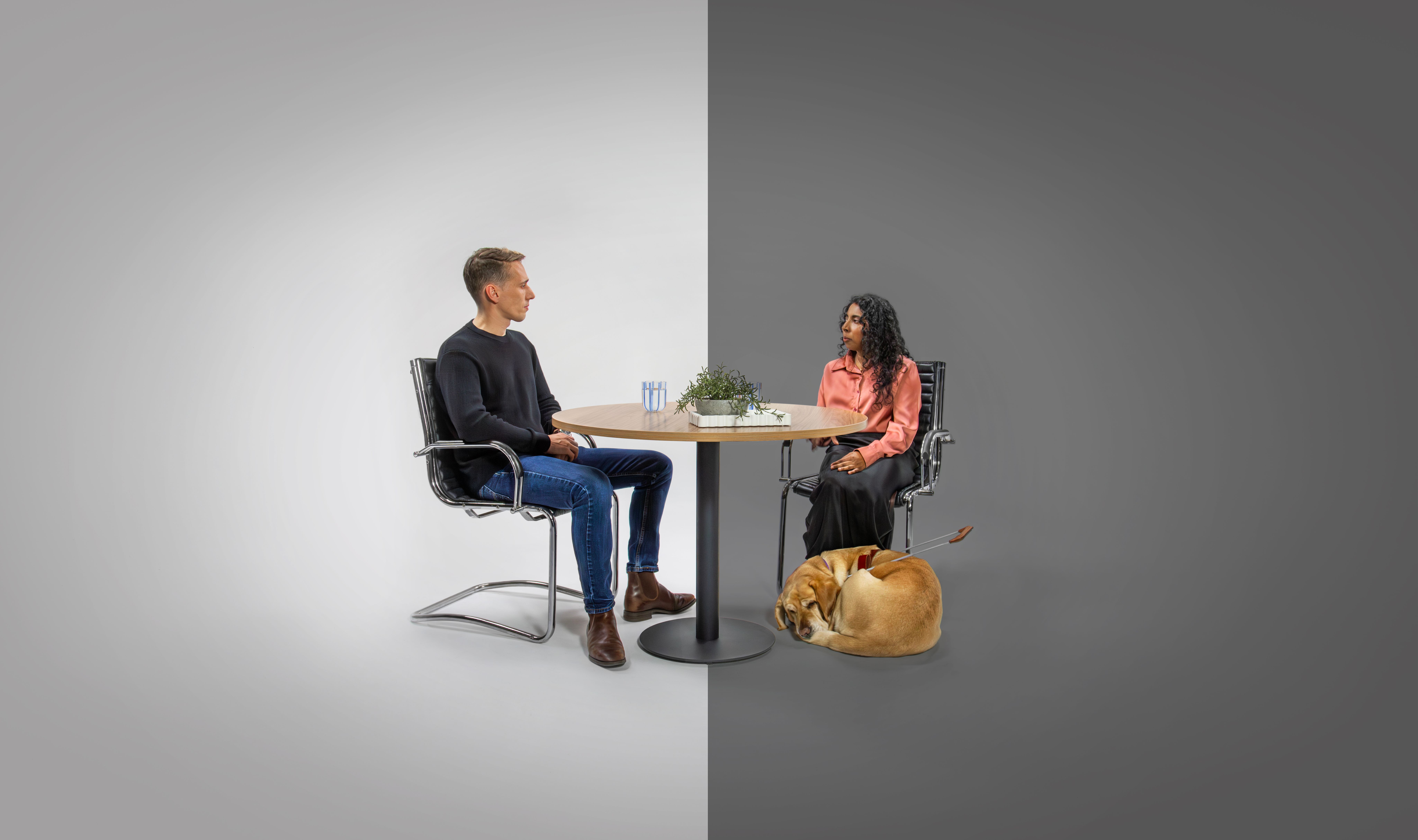 Two people sitting at a desk facing each other.