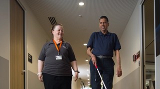 A staff member walking with a Client.