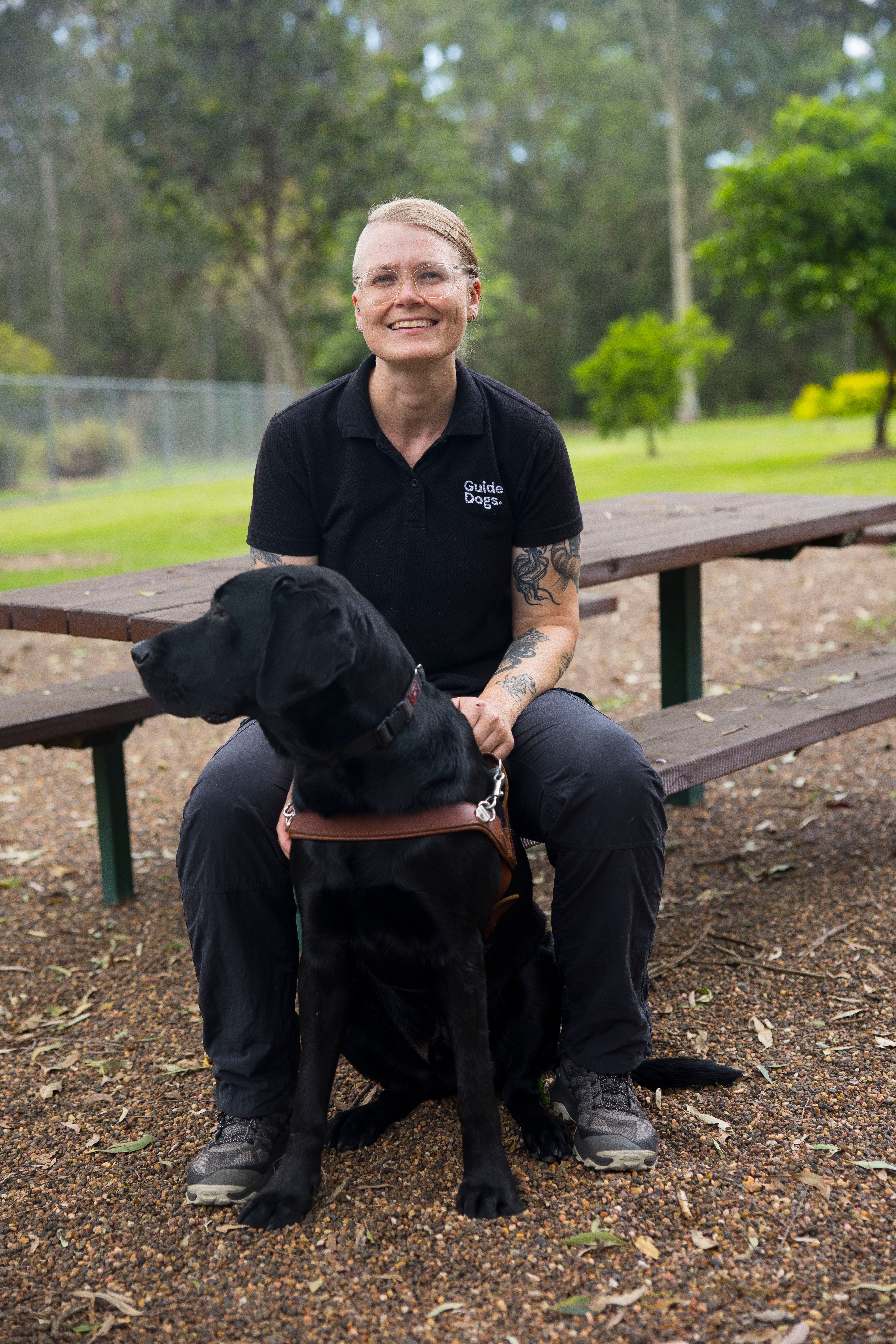 A Trainer sitting with a Guide Dog.