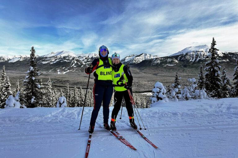 Taryn on a mountain with her Ski Guide.
