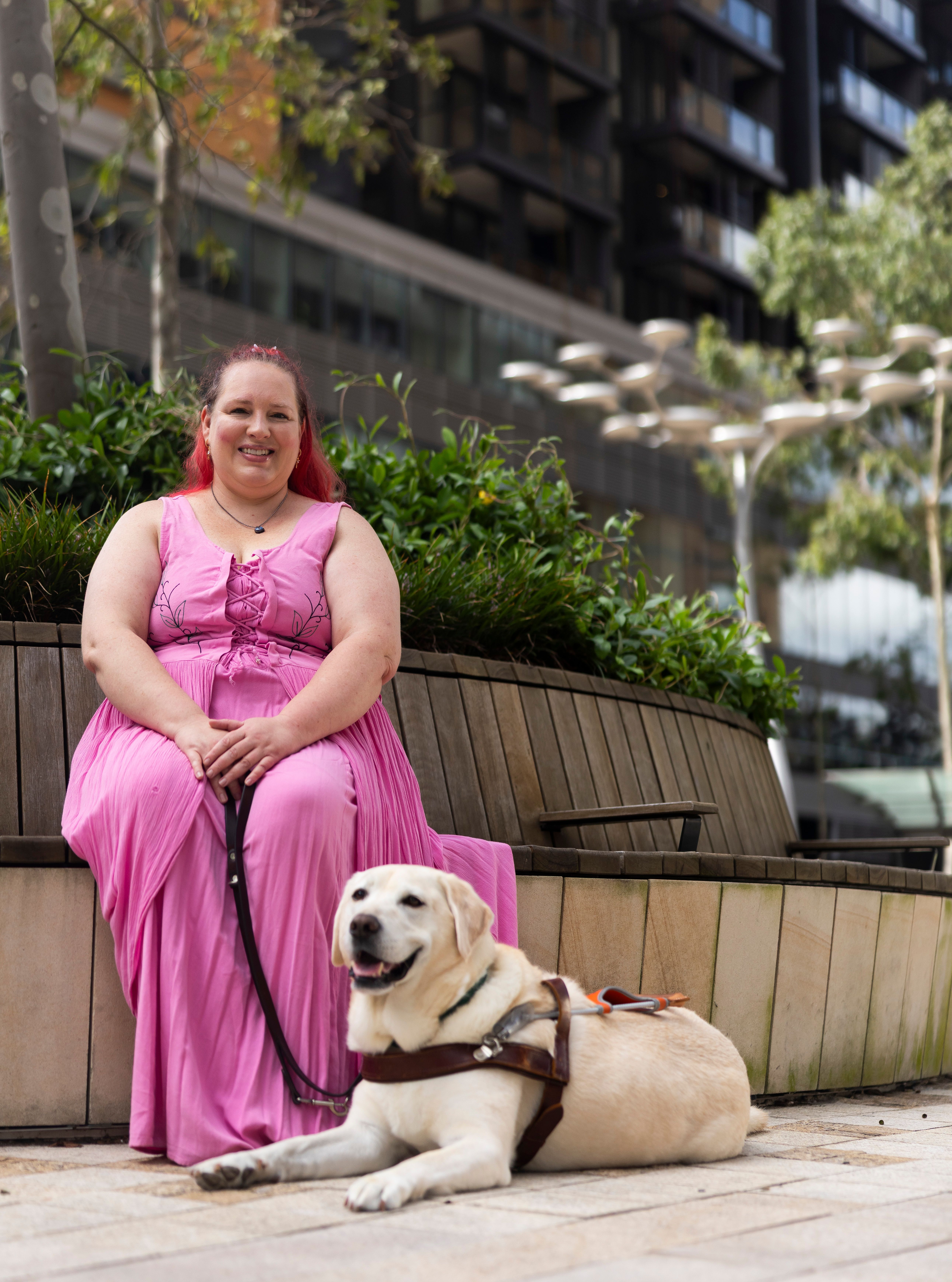 A Handler sitting with their Guide Dog.