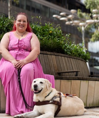 A Handler sitting with their Guide Dog.