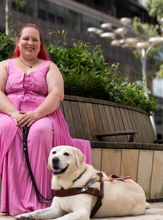 A Handler sitting with their Guide Dog.