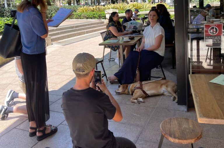Sarah Hirst with her Guide Dog at a cafe.