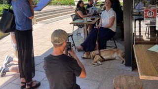 Sarah Hirst with her Guide Dog at a cafe.
