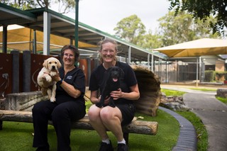 Two volunteers holding puppies.