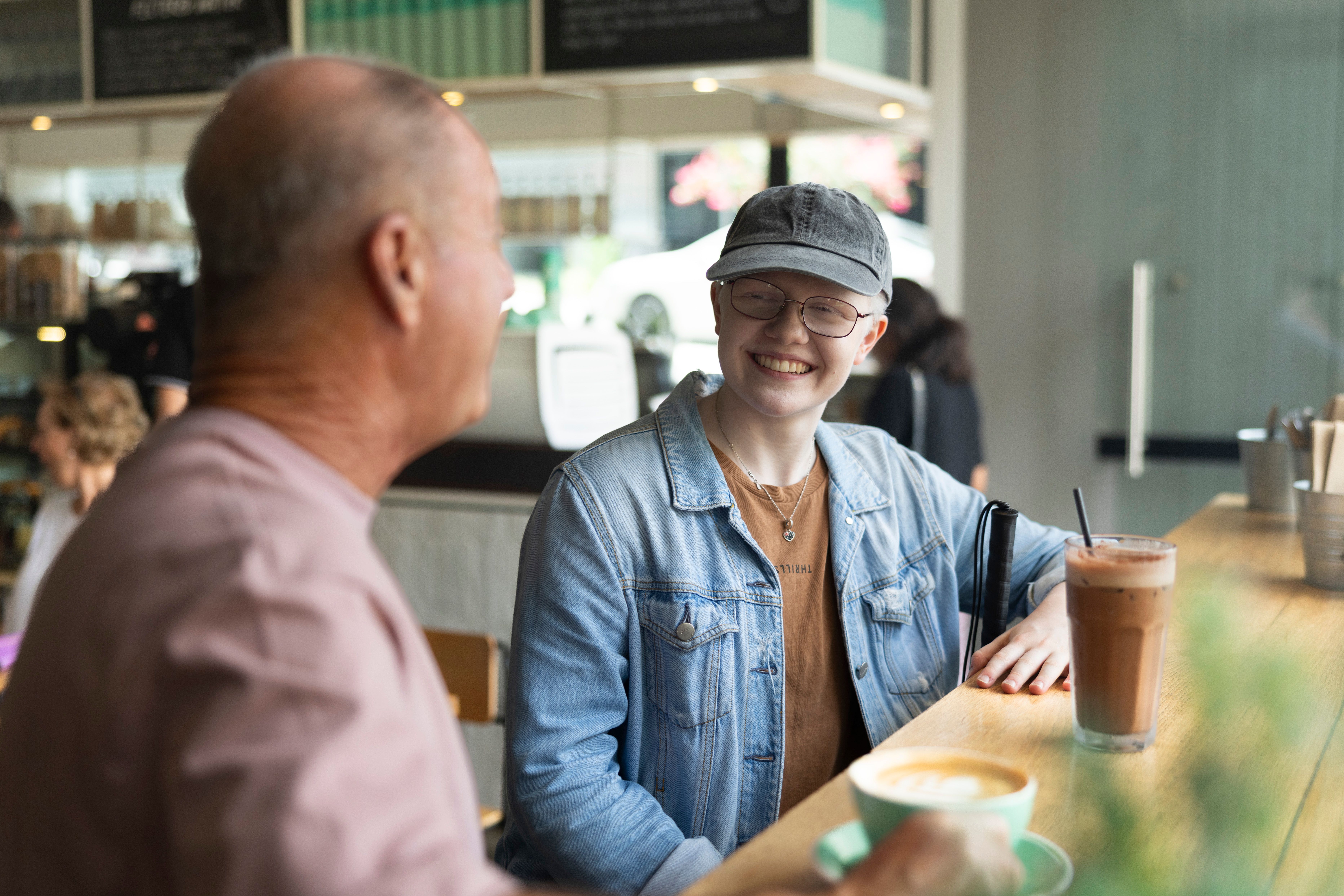 Two Clients sitting at a Cafe with each other.