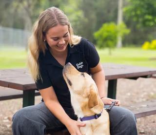 A Guide Dog Trainer sitting with a Guide Dog.