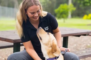 A Guide Dog Trainer sitting with a Guide Dog.
