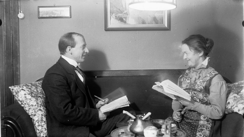 Sort hvitt-bilde av to personer som leser. 