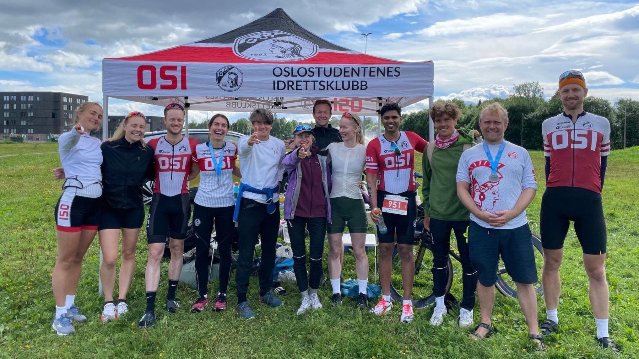 En gruppe triatleter foran klubbens partytelt.