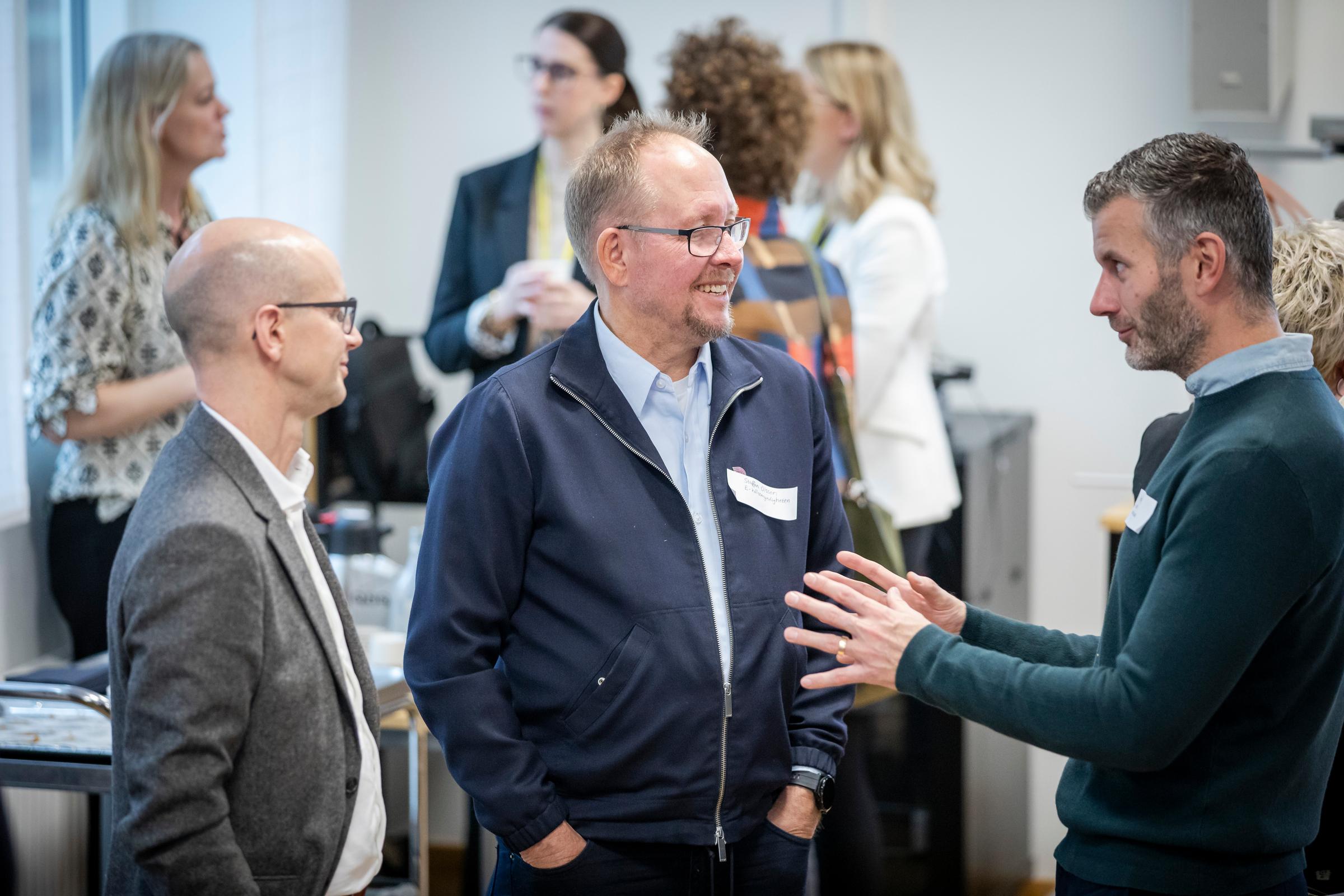 Tre herrar som står och nätverkar på ett av eHealth Arenas nätverksevent.