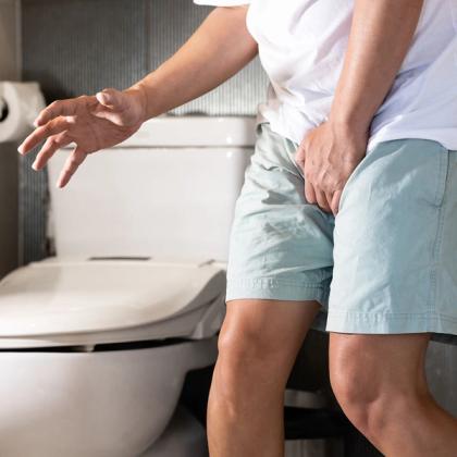 Person experiencing back pain while reaching for restroom in a home setting
