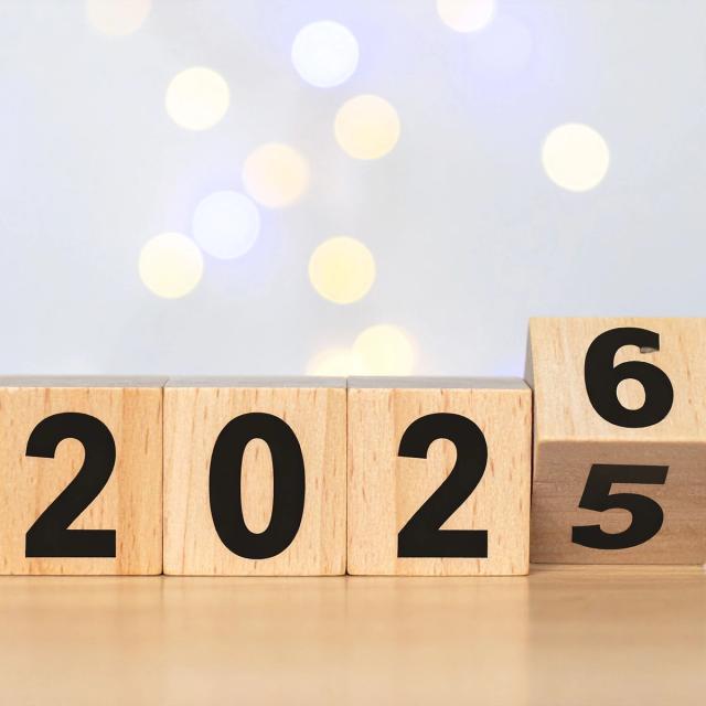 Wooden blocks show the year changing from 2025 to 2026.