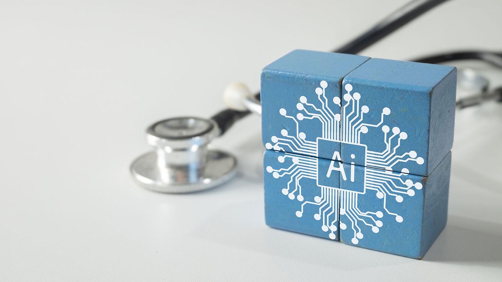 Blue cube with "AI" circuit board graphic next to a stethoscope.