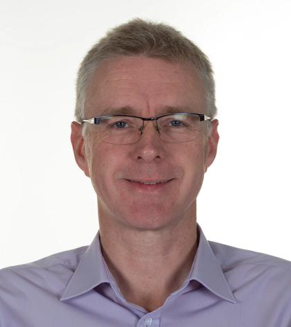 Portrait of a smiling middle-aged man wearing glasses and a light purple shirt against a white background