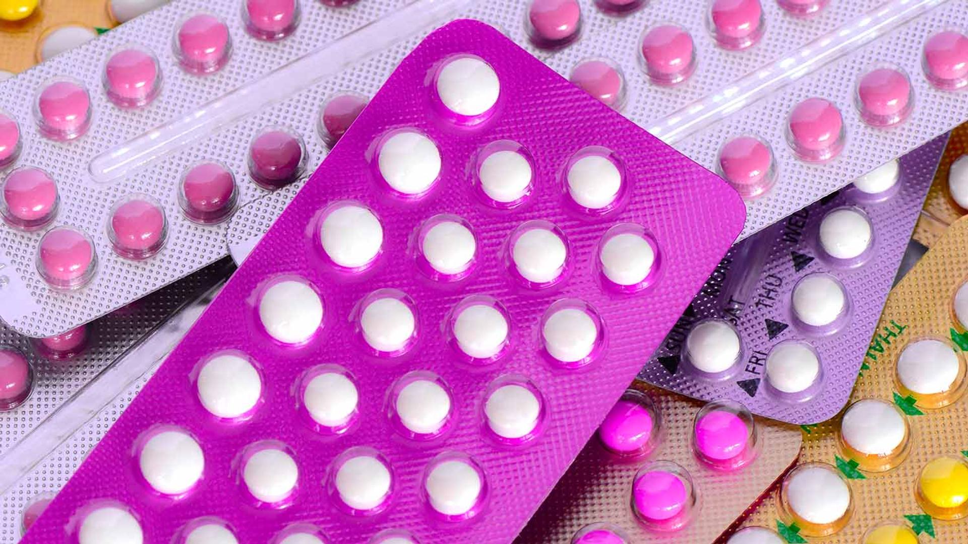 Assortment of birth control pill blister packs in various colors.