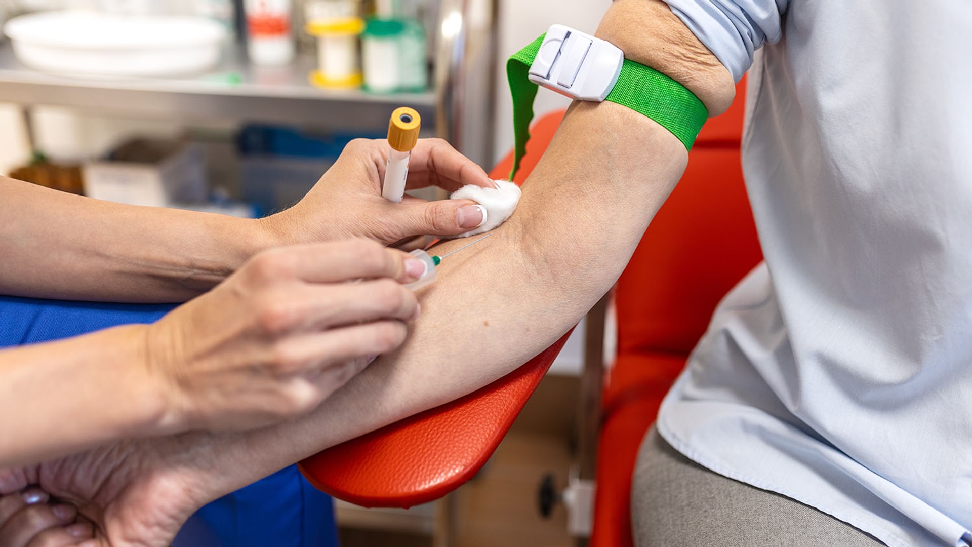 A healthcare worker drawing blood from a patient's arm.