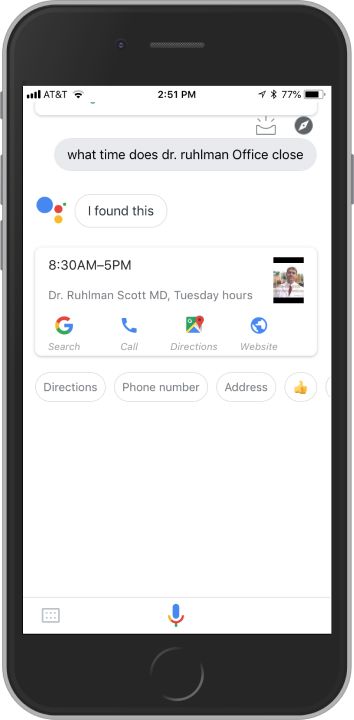 Google Assistant app on iPhone with the results of a “what time does dr. ruhlman office close” query. The results displayed include a card with “8:30AM–5:00PM” and the label, “Dr. Ruhlman Scott MD, Tuesday hours,” as well as links to call the office, search on Google, get directions, and visit a website. Additionally, there are four buttons labeled with the words “directions,” “phone number,” and “address,” and a thumbs-up emoji.