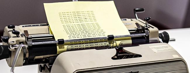 Vintage typewriter with a sheet of paper half covered in text loaded in