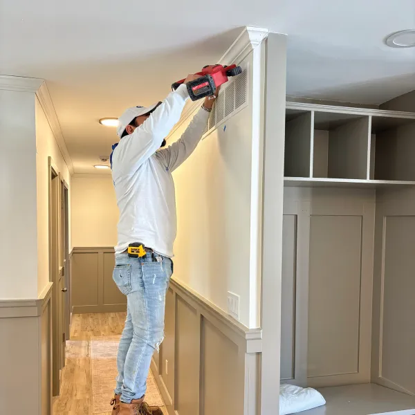 Residential home's interior full repaint and crew member installing crown molding, custom lockers/mudroom.