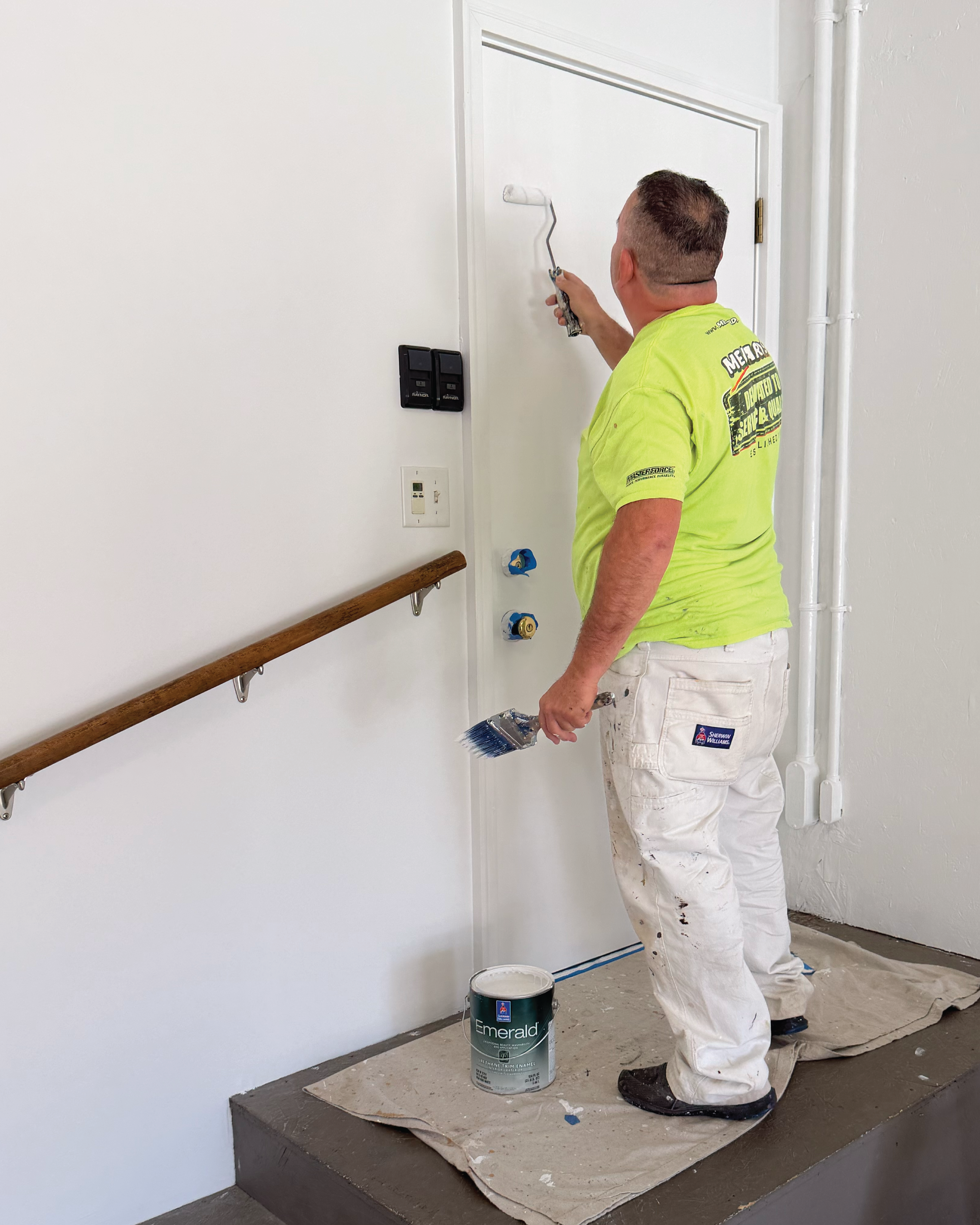Residential home's interior full repaint and crew member painting garage door.